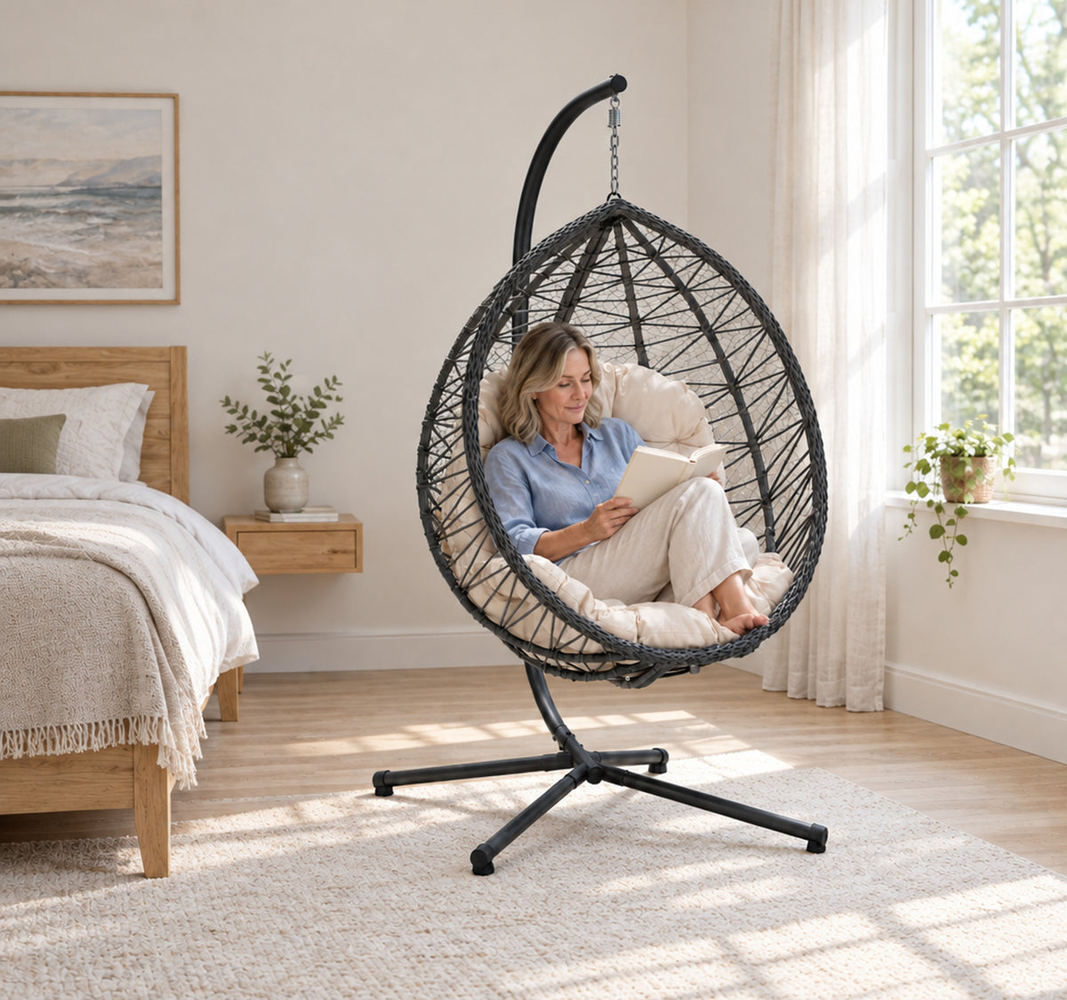 Une lectrice assise dans le Capri blanc crème et gris ; fauteuil et support complets, paysage sans bandes blanches.