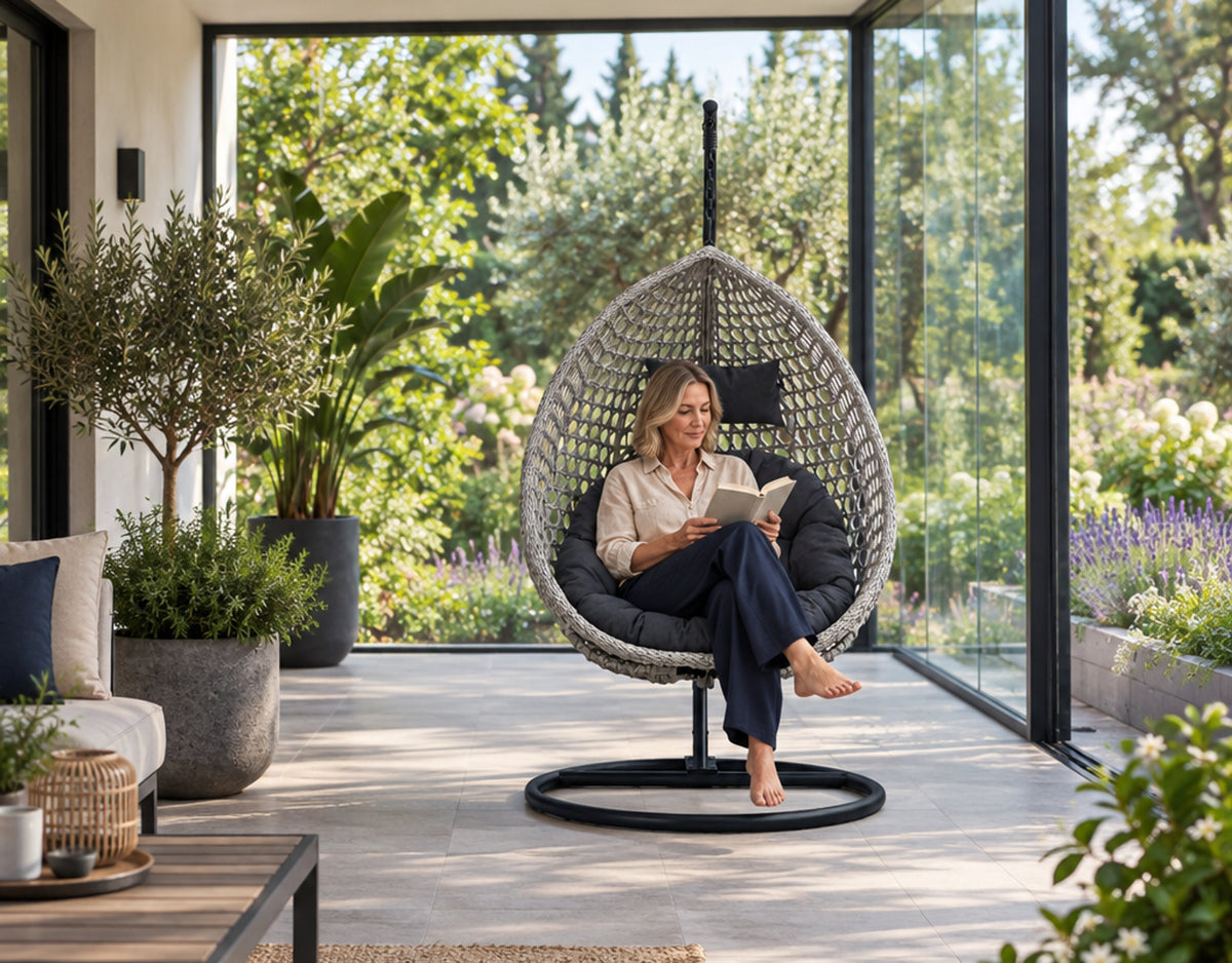 Une femme lit dans le Bali gris foncé et gris ; le pied et le support sont entièrement visibles.